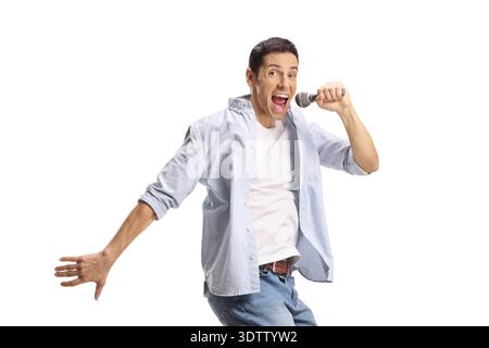 Young man jumping and singing on a microphone isolated on white background Stock Photo