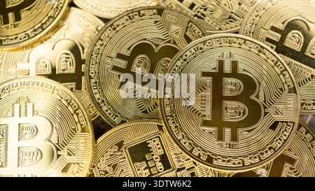Physical golden bitcoin coins stacked together representing digital cryptocurrency investment. Virtual decentralised economy and blockchain technology Stock Photo