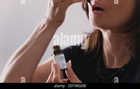 Female Uses A Hemp Cbd Oil Dropper For Wellness Routine And Peace Of Mind Stock Photo