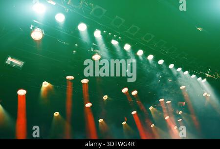glowing ceiling green spotlights working during the musical concert, lights the stage Stock Photo