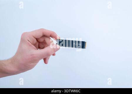 M2 ssd solid state drive held in hand isolated on white background, high speed nvme storage hardware Stock Photo
