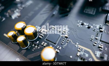 Close up macro of printed circuit board with capacitors and microchip, detailed electronic components on modern motherboard technology background Stock Photo