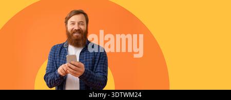 Man Holding Smartphone in Front of Orange Background With Circular Pattern Stock Photo