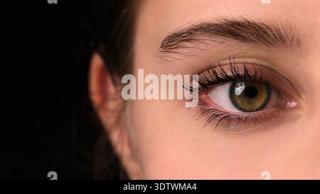 Girl Widely Opens Her Large Green Eye For A Close-Up View Stock Photo