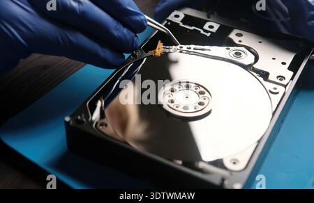 Serviceman repairs hdd data disk in service center Stock Photo