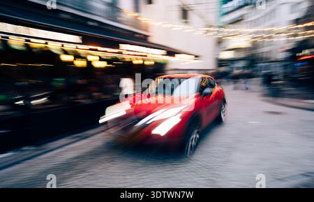 Red Car Moves With Dynamic Motion Blur On The City Street Stock Photo
