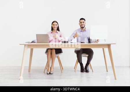 Couple Working Together in an Office With a Laptop and Documents on the Desk Stock Photo