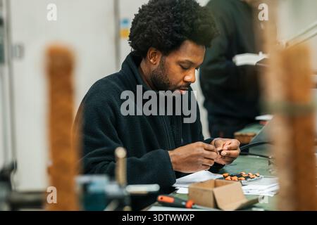 Concentrated male worker working on mechanics in factory Stock Photo