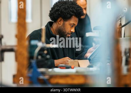 Focused male worker using tablet PC while working in factory Stock Photo