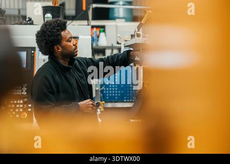 Male worker working on machine in production factory Stock Photo