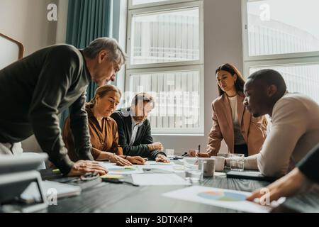 Group of focused business professionals examining reports in meeting at office Stock Photo