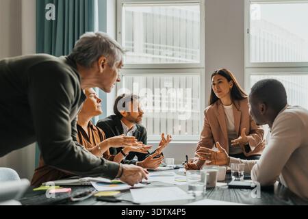 Team of corporate professionals discussing ideas in group meeting at office Stock Photo