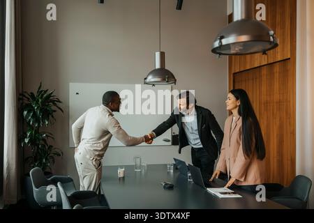Male manager doing handshake with candidate after interview at office Stock Photo