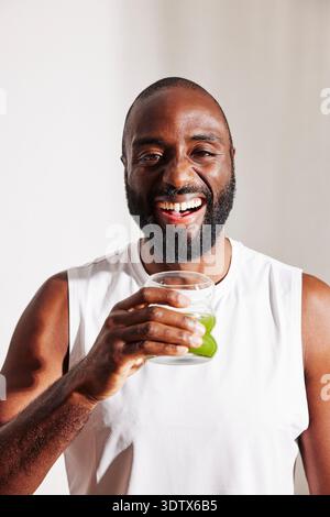 Portrait of happy bearded man holding detox juice glass in hand Stock Photo