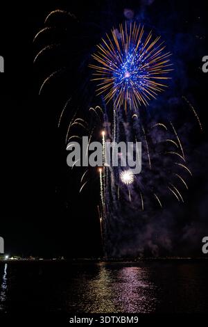 Ferragosto pyrotechnic spectacle over the sea in Grado Italy 2025: spectacular fireworks explosions at night, vibrant bursts reflecting on water. Stock Photo