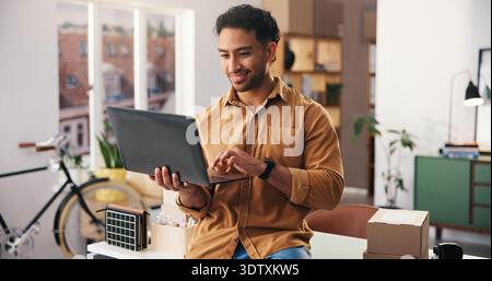 Business, logistics and man in office, laptop for inventory management and online order. Person, entrepreneur or owner in workplace, computer or email Stock Photo