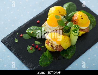 Close up of mini burgers from quail eggs with baked potatoes at plate with greens Stock Photo