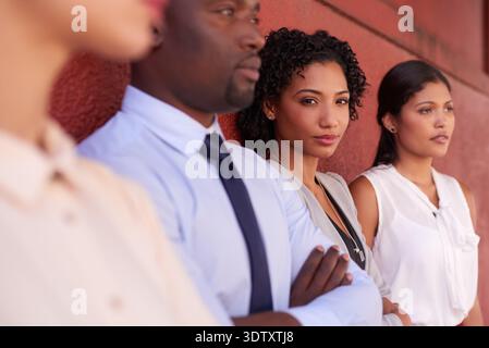 Serious, city and portrait of business people by wall with teamwork, collaboration or confidence. Professional, diversity and group of corporate Stock Photo