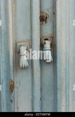 Old decorative hand shaped door knockers on a traditional blue painted door on an house in the Tunisian Kasbah, typical of homes in North Africa and t Stock Photo