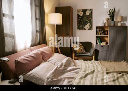 Cozy Modern Bedroom Interior Featuring Sunlight Streaming through Window Stock Photo