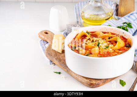 Warming comfort food, tasty chicken Lasagna Soup with tomato sauce, ground chicken meat fillet, grated cheese and wide lasagne pasta sheets Stock Photo