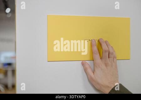 Man Reading Braille Signage Inside Library Setting Stock Photo