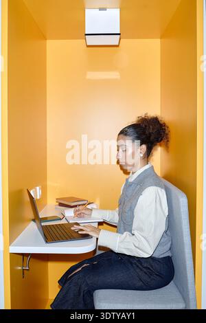 Young Adult Woman Using Laptop in Library Stock Photo