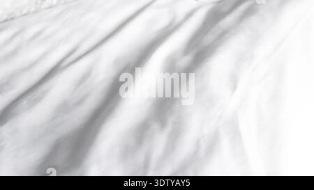 Detailed view of white fabric showcasing soft folds and creases in natural light Stock Photo
