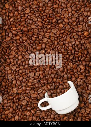 Roasted coffee beans and a white espresso cup. Culinary background. Top view, selective focus Stock Photo