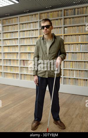 Middle Aged Blind Man Using Cane Navigating Library Stock Photo