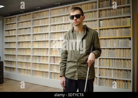 Middle Aged Man Using Cane Navigating Library While Blind Stock Photo