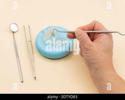 Orthodontic treatment planning showing a dental arch expander on a case with instruments and a hand Stock Photo