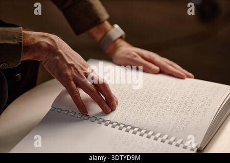 Adult Man Touching Braille Textbook Pages While Studying in Library Stock Photo