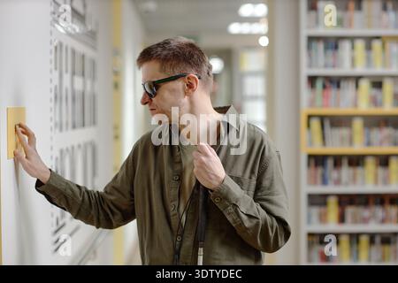 Middle Aged Man Using Tactile Signage Navigating Library Independently Stock Photo