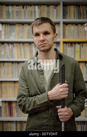 Portrait of Young Adult Man Navigating Library While Being Blind Stock Photo