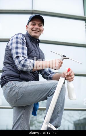 male cleaner washes windows and store front Stock Photo
