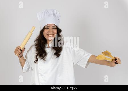 Smiling female chef holding rolling pin and dough Stock Photo