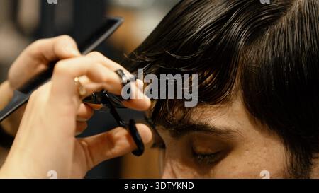 Barber hands using scissors for precise haircutting process Stock Photo