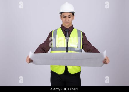 Male engineer with blueprints looking at the project Stock Photo