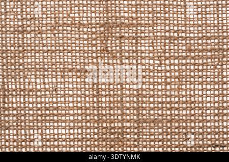 A high-resolution macro photograph of natural brown burlap. A detailed close-up of the coarse woven jute fibers. Stock Photo