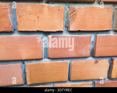 A sharp, close-up view of a traditional red brick wall at Ecseri út. The texture highlights the weathered clay surface and sturdy masonry work, perfec Stock Photo