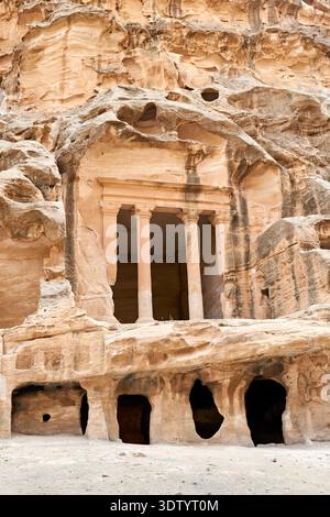 Visitors explore the Little Petra archaeological site in Wadi Musa, where ancient structures are carved into stone. Stock Photo