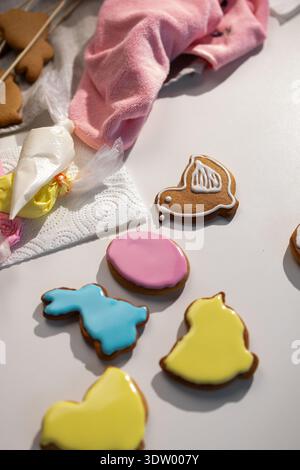 Close up of various Easter gingerbread cookies decorated with vibrant pink, blue, and yellow icing. Shapes include a bunny and egg. Stock Photo