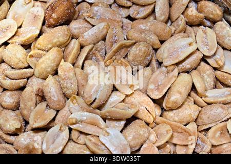 A close view of delicious roasted peanuts lightly coated in salt, showcasing their texture and golden-brown color. Stock Photo