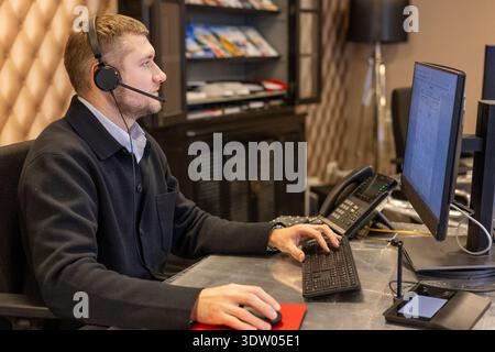 Customer Support Operator Working At Computer With Headset Stock Photo