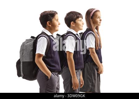 Boys and girls in school uniforms carrying backpacks isolated on white background Stock Photo