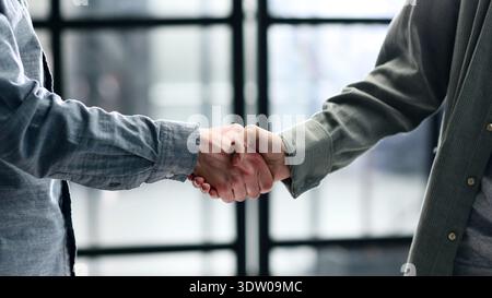 A close-up handshake in the office and a successful deal Stock Photo