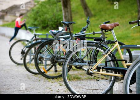 Bicycles in the park against woman stretching Stock Photo