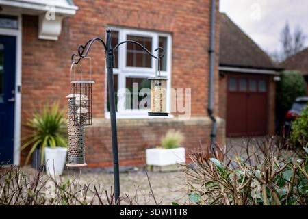 cheerful bouquet of yellow daffodils and tulips placed next to a pink sticky note with a smiley face and the word “SPRING” written on it Stock Photo