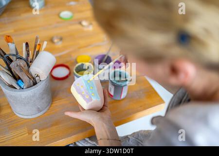 Unrecognisable Female Potter Decorating A Clay Pot In Her Workshop Stock Photo